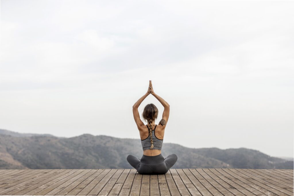 back view woman doing yoga outdoors