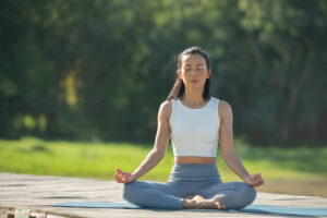 woman on a yoga mat to relax in the park at mountain lake. calm